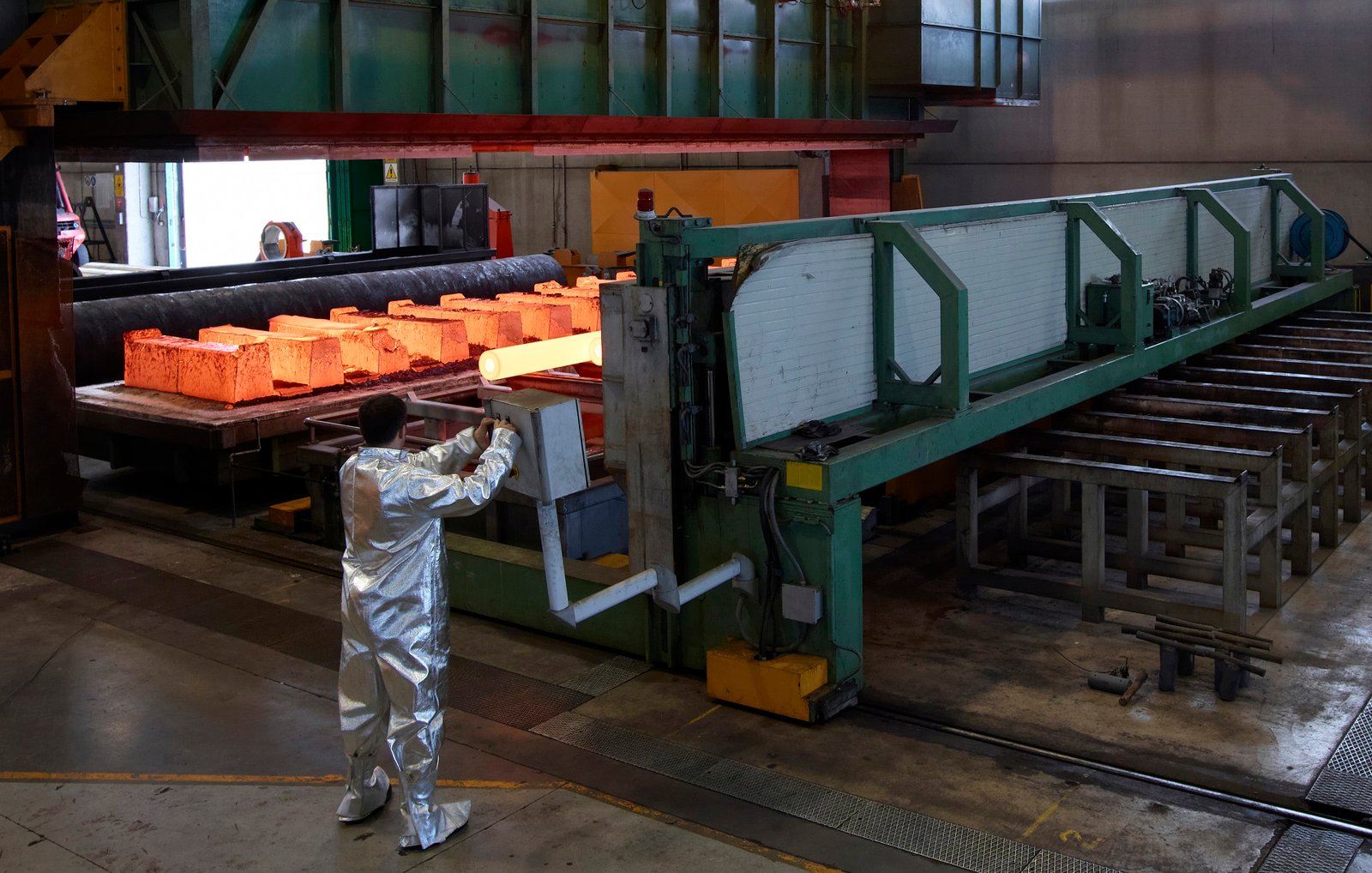 Worker monitoring hot steel production in an industrial setting